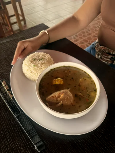 Sopa de gallina con maíz servida junto a arroz blanco, vista desde arriba