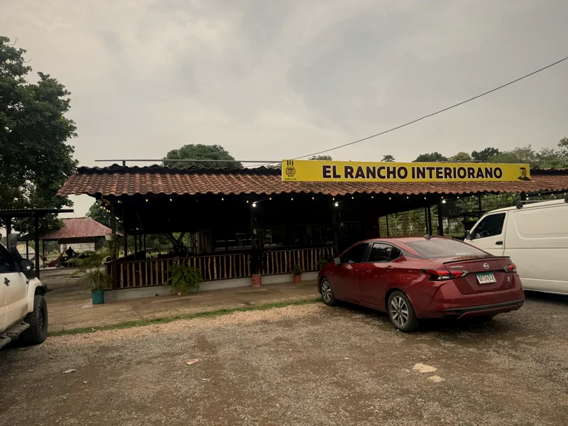 Fachada de El Rancho Interiorano vista desde el estacionamiento, con el letrero del negocio y luces colgantes
